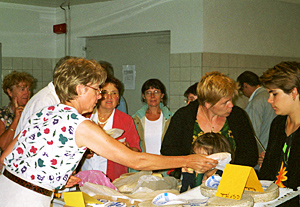 Nicole selling cheese after the tour. Yves pitches in to help.