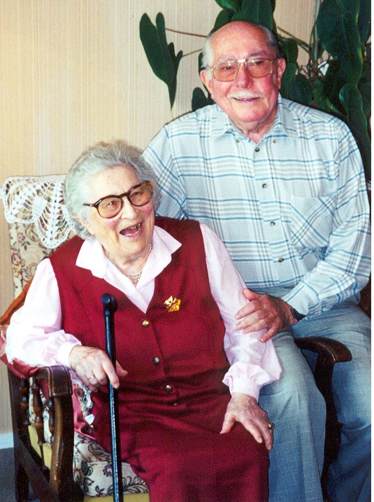 An elderly woman and an elderly man seated together