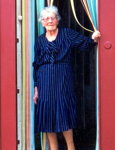 An elderly woman standing in a doorway
