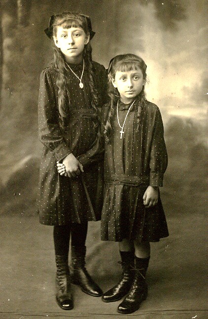 Old photograph of two girls in dark dresses