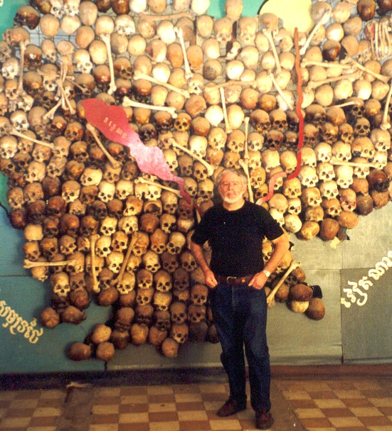 A man standing in front of a wall of skulls
