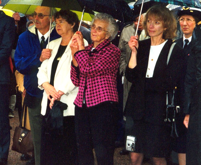 People holding umbrellas at an outdoor ceremony