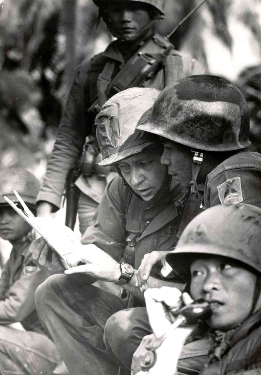 This is a classic war photo. Capt. Fraley and the Vietnamese commander of the troops are poring over a map and discussing the operation. You can see...