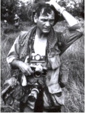 A photographer carrying cameras in the field