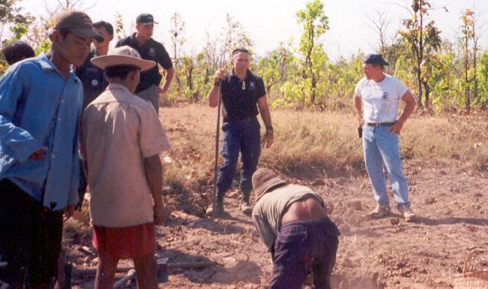 A group of men at an excavation site in open scrubland