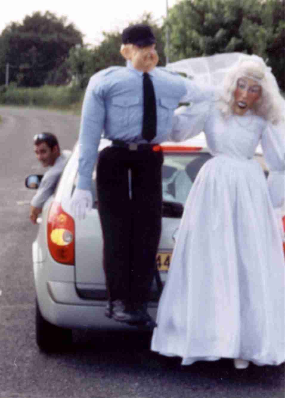 A bride and groom beside a car