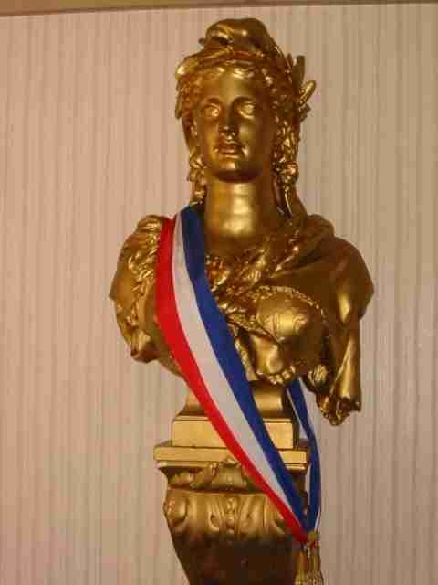 A gilded bust of Marianne wearing a tricolor sash