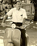 A young man riding a motor scooter